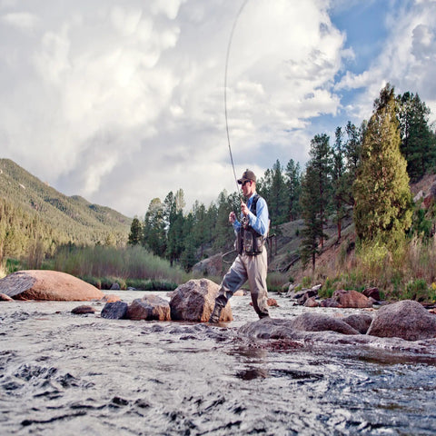 Angler wearing Ultra Lightweight Fly Fishing Vest With 14 Pockets And Front Zip Storage Olive Green on riverbank