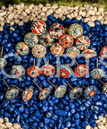 20 Piece Retro Look Flower Ceramic Cabinet Knob Set With Chrome Hardware For Cabinets And Drawers Hand Painted Multicolor Blue Creamy Red 42mm Diameter 30mm Bolt 30 To 55mm Knob Length displayed on blue and white pebbles