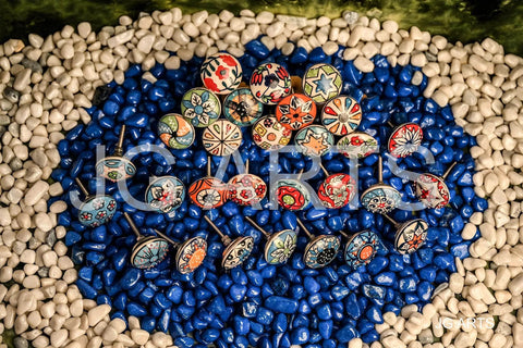 20 Piece Retro Look Flower Ceramic Cabinet Knob Set With Chrome Hardware For Cabinets And Drawers Hand Painted Multicolor Blue Creamy Red 42mm Diameter 30mm Bolt 30 To 55mm Knob Length displayed on blue and white pebbles