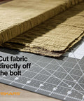 Fiskars self-healing cutting mat with folded fabric on top, gray grid surface, 24 x 36 inches