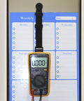 Magnetic Hanger Kit For Fluke Multimeters With Strap And Clip holding a multimeter on a metal surface for hands-free use