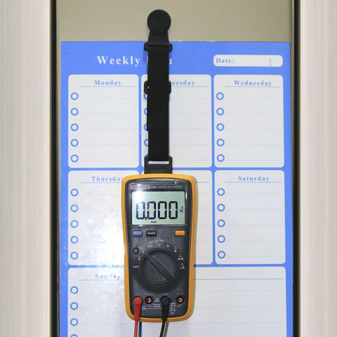 Magnetic Hanger Kit For Fluke Multimeters With Strap And Clip holding a multimeter on a metal surface for hands-free use