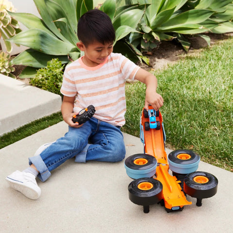 Child playing with Monster Trucks RC Toy With Transforming Rhinomite, 1:12 Scale Monster Truck And 1:64 Scale Race Ace outdoors