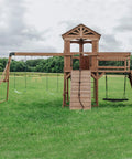 Cedar Wood Swing Set With Wave Slide And Raised Clubhouse Plus Balcony, Wooden Bridge, Rock Wall, Belt And Web Swings in backyard