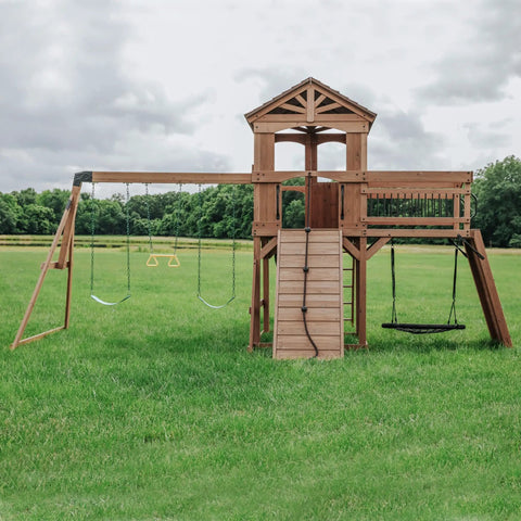 Cedar Wood Swing Set With Wave Slide And Raised Clubhouse Plus Balcony, Wooden Bridge, Rock Wall, Belt And Web Swings in backyard
