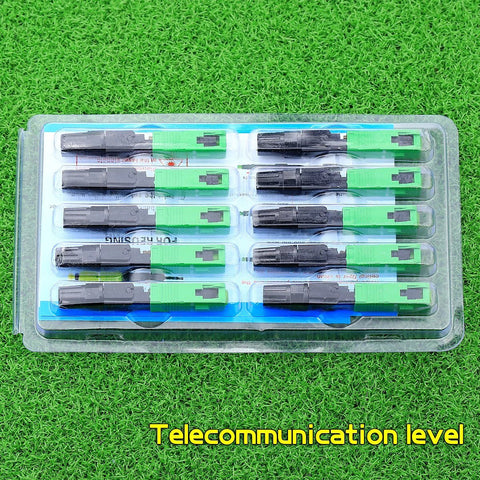 Front view of blister-pack with 12 FTTH SC APC optical fiber quick connectors in green and black plastic housings.