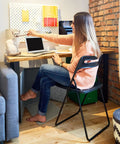 Woman using foldable foot and leg heater with blanket, portable under desk space warmer for home or office