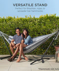 Heavy Duty 9 Foot Steel Hammock Stand With Built In Wheel For Easy Mobility Carrying Case Weather Resistant Finish And 450 Pound Capacity Your Go To Outdoor Yard Setup shown with hammock and seated people, greenery background