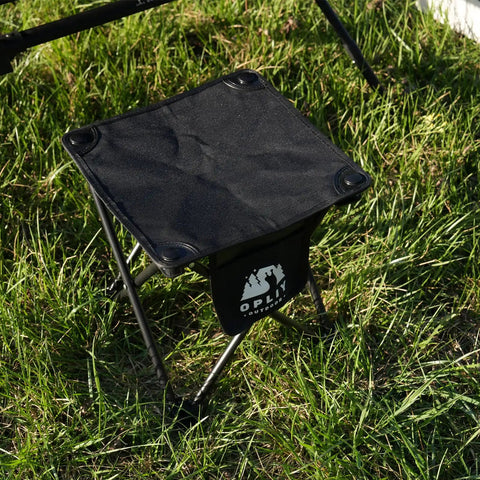 Two Pack Folding Camping Stool With Upgraded Latch Buckle on grass, black 600D Oxford cloth, steel frame shown