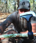 Man holding Five In One Survival Hatchet Head With Skinner Ulu Hammer Ripper And Gut Hook Leather Sheath in the woods.