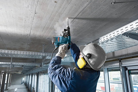 Worker using Two Cutter Head Three Quarter Inch By Twenty Four Inch SDS Plus Bulldog Rotary Hammer Bit for ceiling drilling.