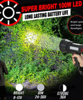 Person using Rechargeable 100000 Lumen Spotlight With COB Flood Light, illuminating a forest area at night with bright beam.