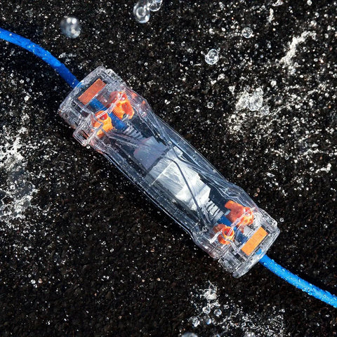 Weatherproof Extension Cord Protector with clear housing on wet surface, sealing 12-gauge blue cord, IP55 and IK09 rated