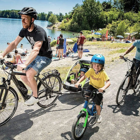Family biking near lake with kids trailer using Bike Trailer Hitch Connector And Cycling Adapter For Kids Trailers Cargo And Pet Trailers
