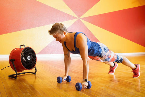 16 Inch High Velocity Drum Fan With Pivoting Head Turbo Power in a gym setting, providing cooling during a workout session.