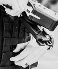 Person securing Rock Solid 3 Inch Molle Lok Clips onto tactical vest with nylon webbing, ideal for outdoor gear.