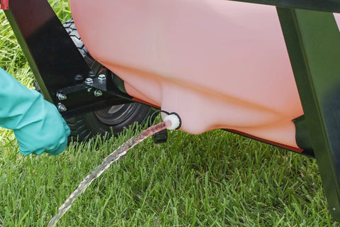 Water flowing from a 60-Gallon Tow Behind Sprayer With 60 Gallon Capacity, 4 GPM Diaphragm Pump onto grass during lawn care