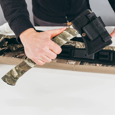 Person holding axe wrapped with Self Cling Camouflage Fabric Wrap For Gear And Knives, Reusable And Washable, No Sticky Residue