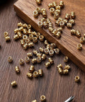 Bulk Pack of 300 Brass M4 Heat Set Threaded Inserts Knurled For Plastic on wooden surface