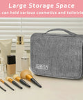 Compact Hanging Toiletry Bag With Hook Waterproof Travel Organizer for men and women, gray, on table with cosmetics