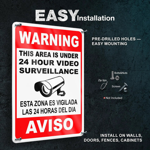 The Real Deal 24 Hour Security Camera Alert Eight By Twelve Inch Reflective Aluminum Yard Sign bold bilingual lettering mounted on a wall.