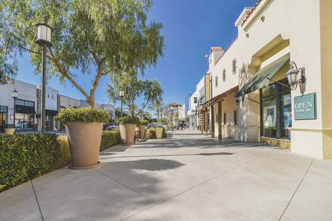 Heavy Duty Five Gallon Concrete Sealer With Water Based Siliconate Formula against sunlight on a clean, modern sidewalk.