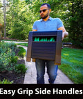 Person carrying Beefy 200 Foot Hose Storage Box With Internal Poly-Resin Reel in garden, Easy Grip Side Handles visible