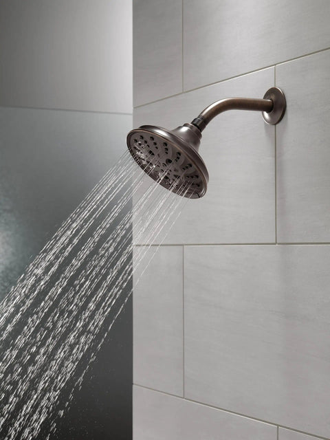 Five Setting Raincan Shower Head With H2Okinetic Spray In Venetian Bronze, Easy Clean Touch Nozzles on a tiled bathroom wall