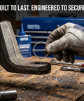 Heavy Duty Stainless Steel Locking Linch Pins With O-Ring Retainers shown in hand securing trailer hitch on wooden workbench.