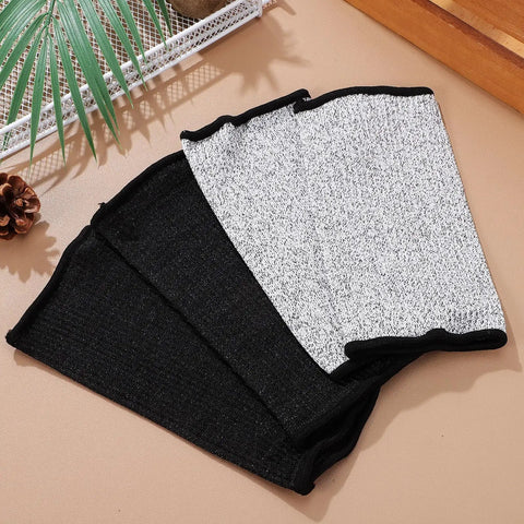 Real Deal Cut Resistant Arm Sleeves For Mechanics And Gardeners With Snug Stretch Fit Anti Puncture Forearm Guards That Make The Daily Grind A Total Breeze In Black Gray laid out on a surface.