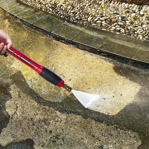 Red Beefy High Power Pressure Washer Gun With 40 Inch Wand Extension in use on a dirty pavement, showing water spray.