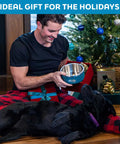 Man holding Game Changer Rock Solid Extra Thick Stainless Steel Dog Bowl 64 Oz with happy black dog in a festive setting.