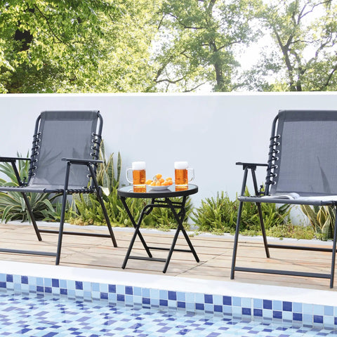 Outdoor Folding Round Patio End Table With Silk Tempered Glass Top And Lightweight Steel Frame set up by a poolside with two chairs