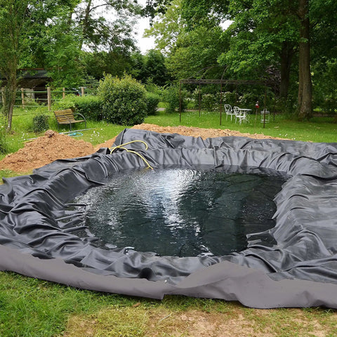 No Stress Heavy Duty Nonwoven Geotextile Underlayment 15 X 15 Feet Weed Barrier Pond Liner around a constructed pond in a garden.