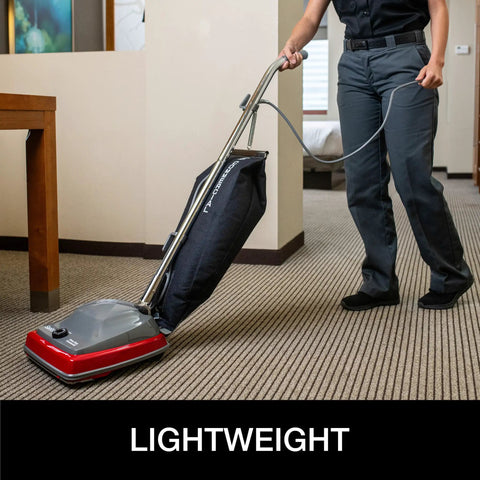 Tradition Upright Commercial Bagged Vacuum Cleaner Workhorse for Heavy Duty Carpet Cleaning, shown in use on office carpet