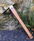 Heavy Duty Stainless Steel Pickaxe Hoe With Wooden Handle For Digging In The Garden beside rock and plants