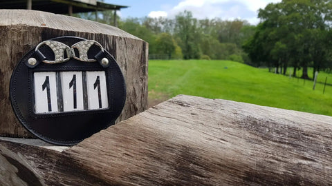 Genuine Leather Number Holders for Bridle or Saddle Pad two pack on wooden post with bling clip.