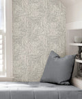 Black Ink Abstract Peel And Stick Wallpaper From Scott Living installed in a cozy reading nook, showing monochrome abstract pattern.