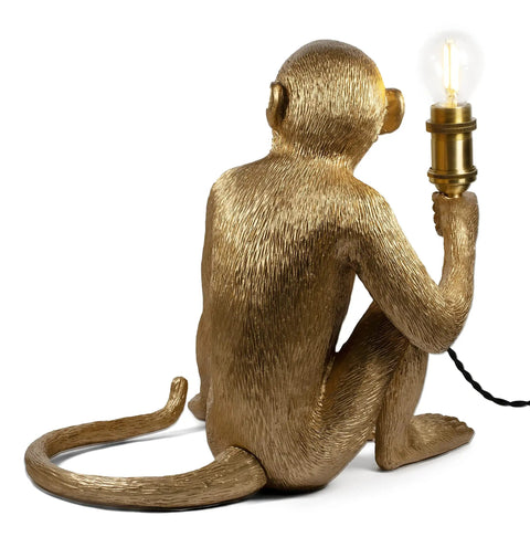 Dope Monkey Desk Lamp Modern Table Light with resin sitting monkey figurine holding a brass socket and twisted fabric cord