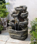 Six Tier Cascading Rock Outdoor Water Fountain With Lights For Garden Patio Backyard Deck And Porch No Fuss Setup With Pump 24.4 Inch High 110V Plug shown installed on a patio