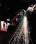 Cloth Grinding Belt 577F 3x132 In 80 YF-Weight, Alumina Zirconia Blend in use on metal, creating sparks during grinding.