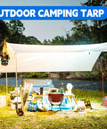 Outdoor setup with Heavy Duty 10X20 Ft White Tarp 12Mil Waterproof UV Resistant Multipurpose Sheet for camping by a river.