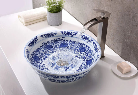 Blue and white porcelain vessel sink with water flowing from a faucet into the bowl