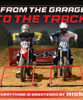 Two motocross riders on dirt bikes poised at the starting line with a banner in the background, ready for the race.