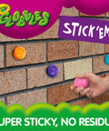 Crayola Globles in various colors stuck to a brick wall, showing super sticky design for fun sensory play.