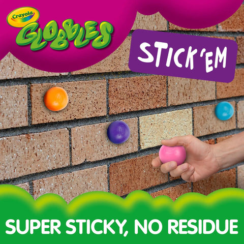 Crayola Globles in various colors stuck to a brick wall, showing super sticky design for fun sensory play.