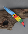 Colorful Parrot Pattern Folding Pocket Knife With Gradient Parrot-Scale Handle, 3-Inch Blue Coated Blade, on a wooden surface