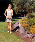 Person watering garden with ColorMark Soft Rain Watering Spray Wand 30 Inch Gold Lightweight Yet Durable With One Touch Lever Valve.