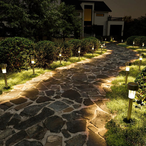 16 Pack Solar Outdoor Lights Pathway Stainless Steel Waterproof LED Landscape Lighting illuminating a stone walkway at night.