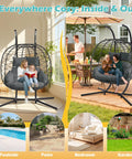 Double Outdoor Hanging Egg Chair With Stand And Oversized Cushion in gray on patio, seating two people, garden background.